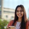 Mina Farouk, Student in Sharjah, holding phone on campus